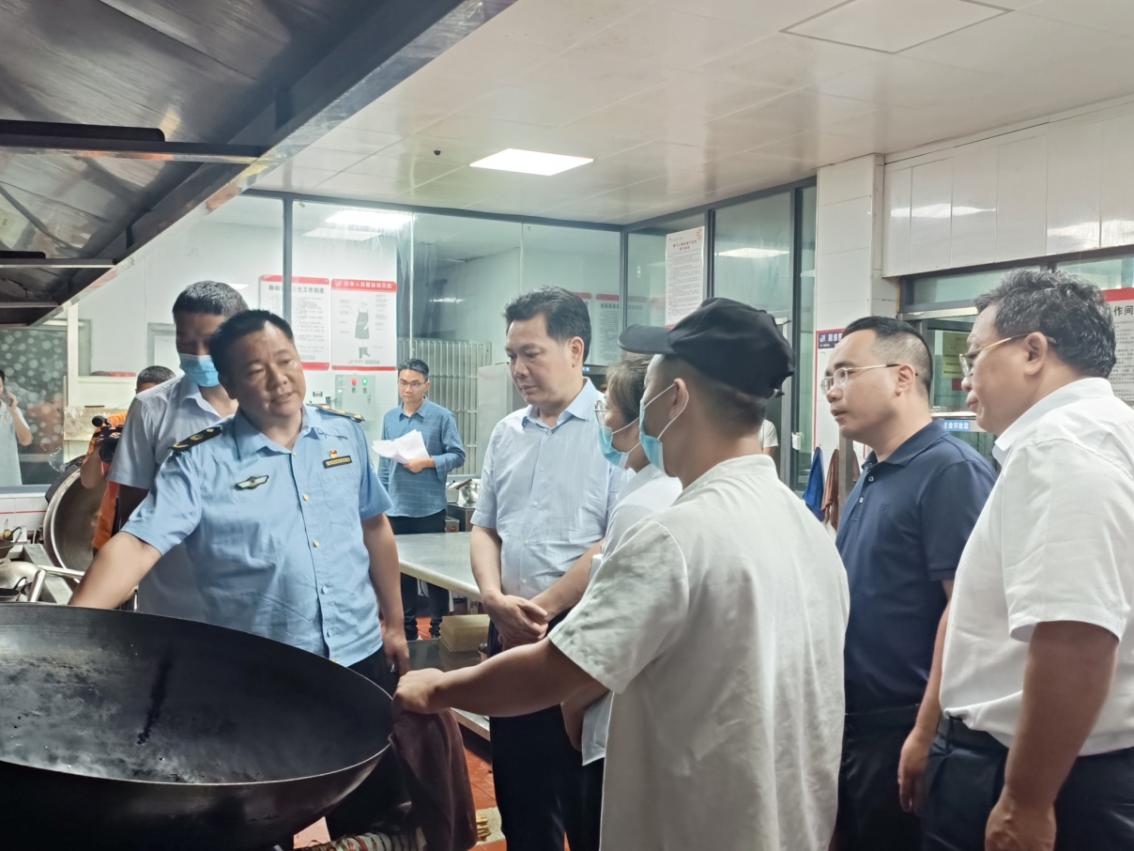 在此输图一 向乾勇现场查看天然气使用器具、让市场监管局领导查验燃气使用是否规范,器具是否经过专业部门定期检验、是否在保质期内,连接灶台的管道是否规范等,查验是否有发生紧急情况的应急处置机制,询问食堂工作人员是否接受过相关培训,发生紧急情况能否有效应对等。